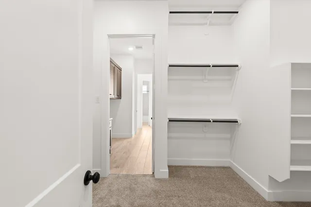 a view of walk in closet with empty racks