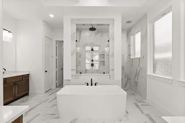 a white bath tub sitting next to a bathroom sink