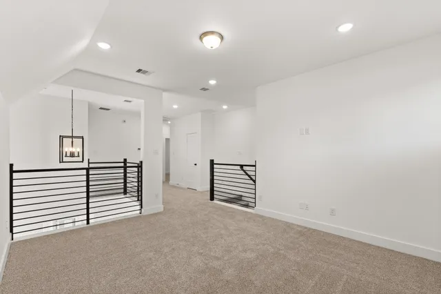 an empty room with a hallway and wooden floor