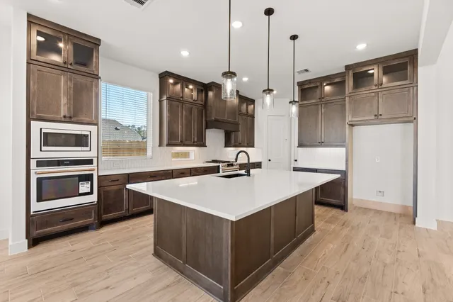 a kitchen with a sink refrigerator and microwave