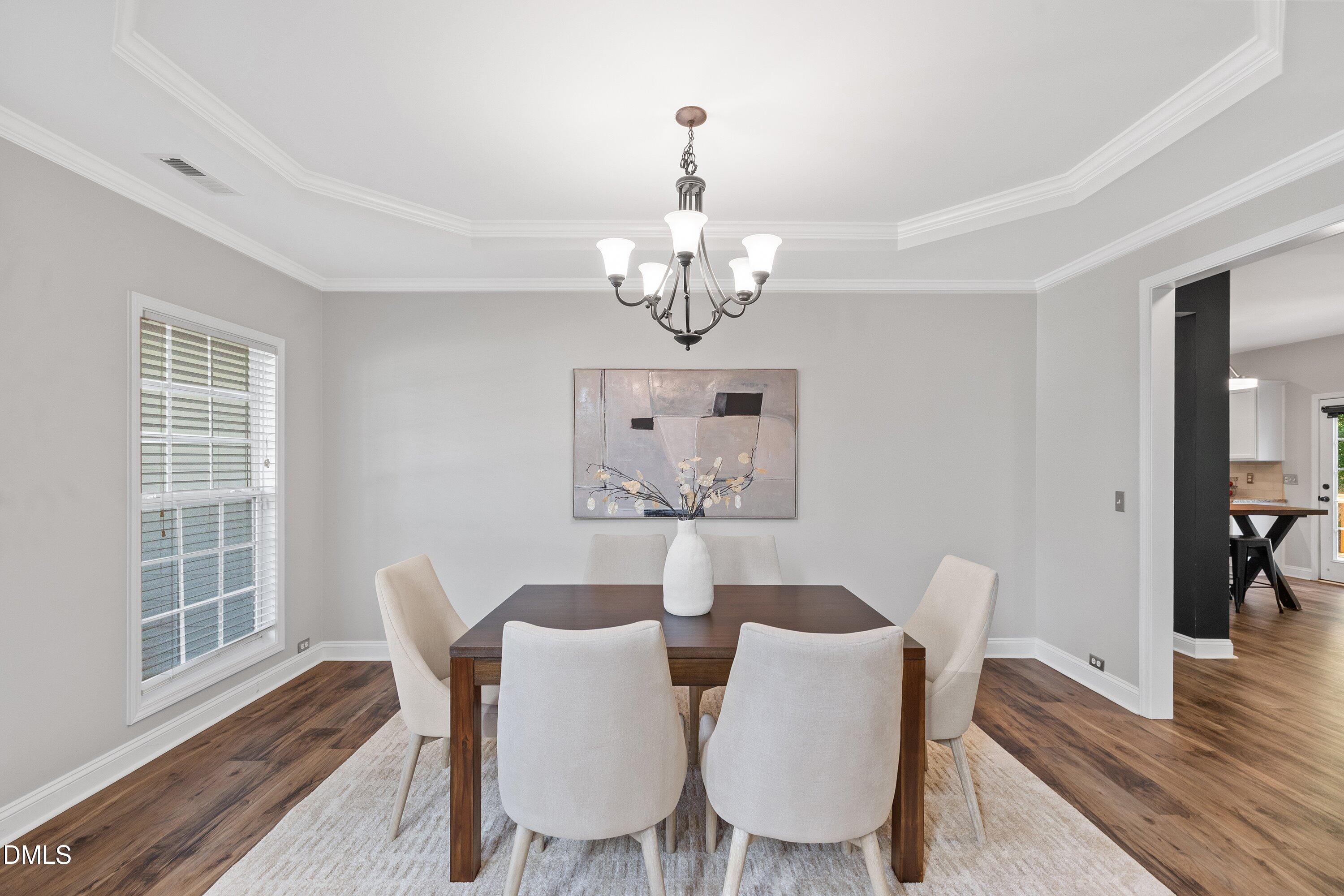 3717 Windmeade Road Wake Forest, NC 27587 - Photo 9 of 51 a view of a dining room with furniture wooden floor and chandelier