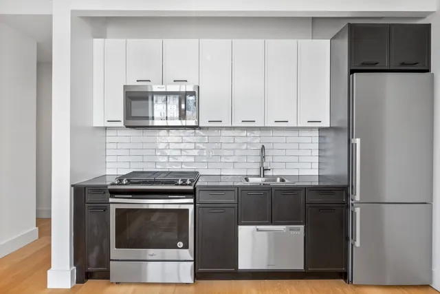 a kitchen with stainless steel appliances a stove a refrigerator and a sink
