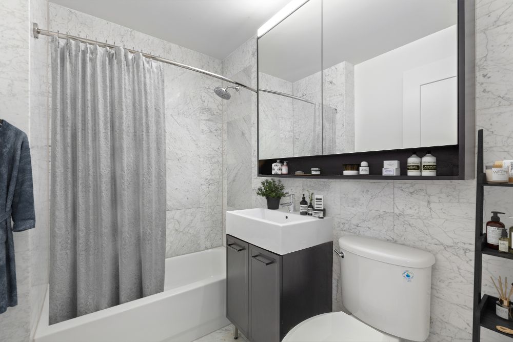 67 Wall Street, Unit 18H Manhattan, NY 10005 - Photo 6 of 20 a bathroom with a sink a toilet and shower