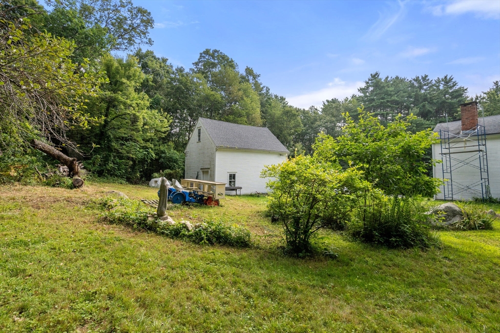 68 Spring Street Hopkinton, MA 01748 - Photo 18 of 28 a backyard of a house with table and chairs plants and large tree
