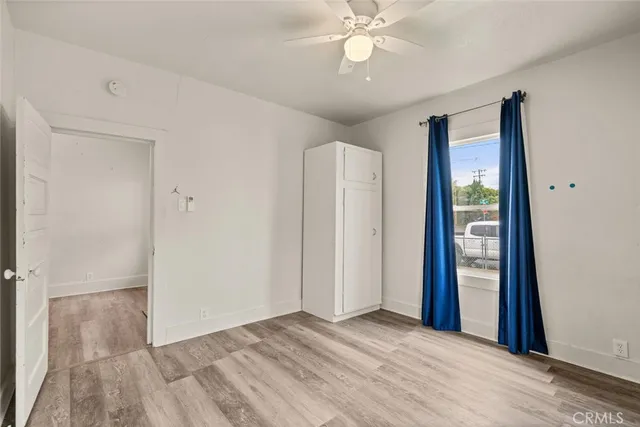 an empty room with a window and a ceiling fan