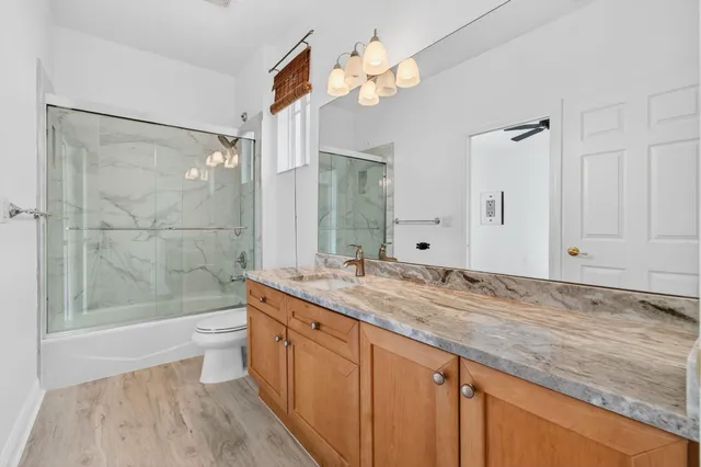 a bathroom with a granite countertop double vanity sink and a mirror