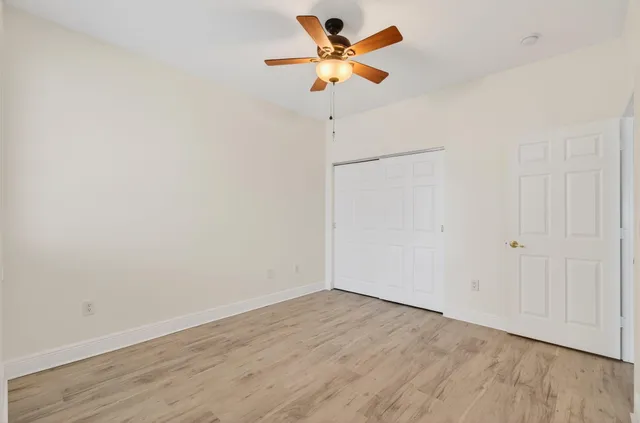 a front view of a house with a yard and potted plants