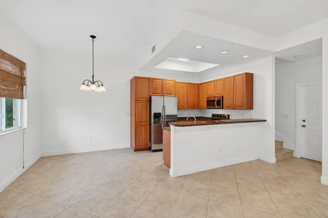 a kitchen with granite countertop a refrigerator stove and microwave