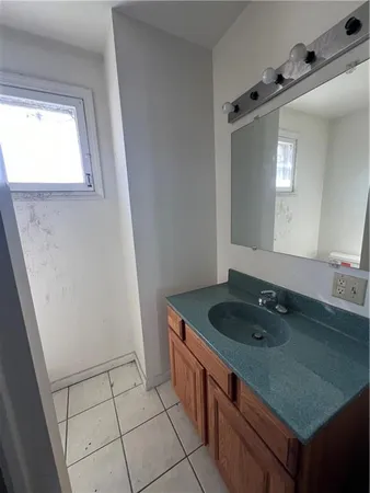 an empty room with chandelier fan and windows