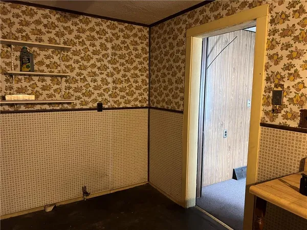 a view of empty room with window and refrigerator