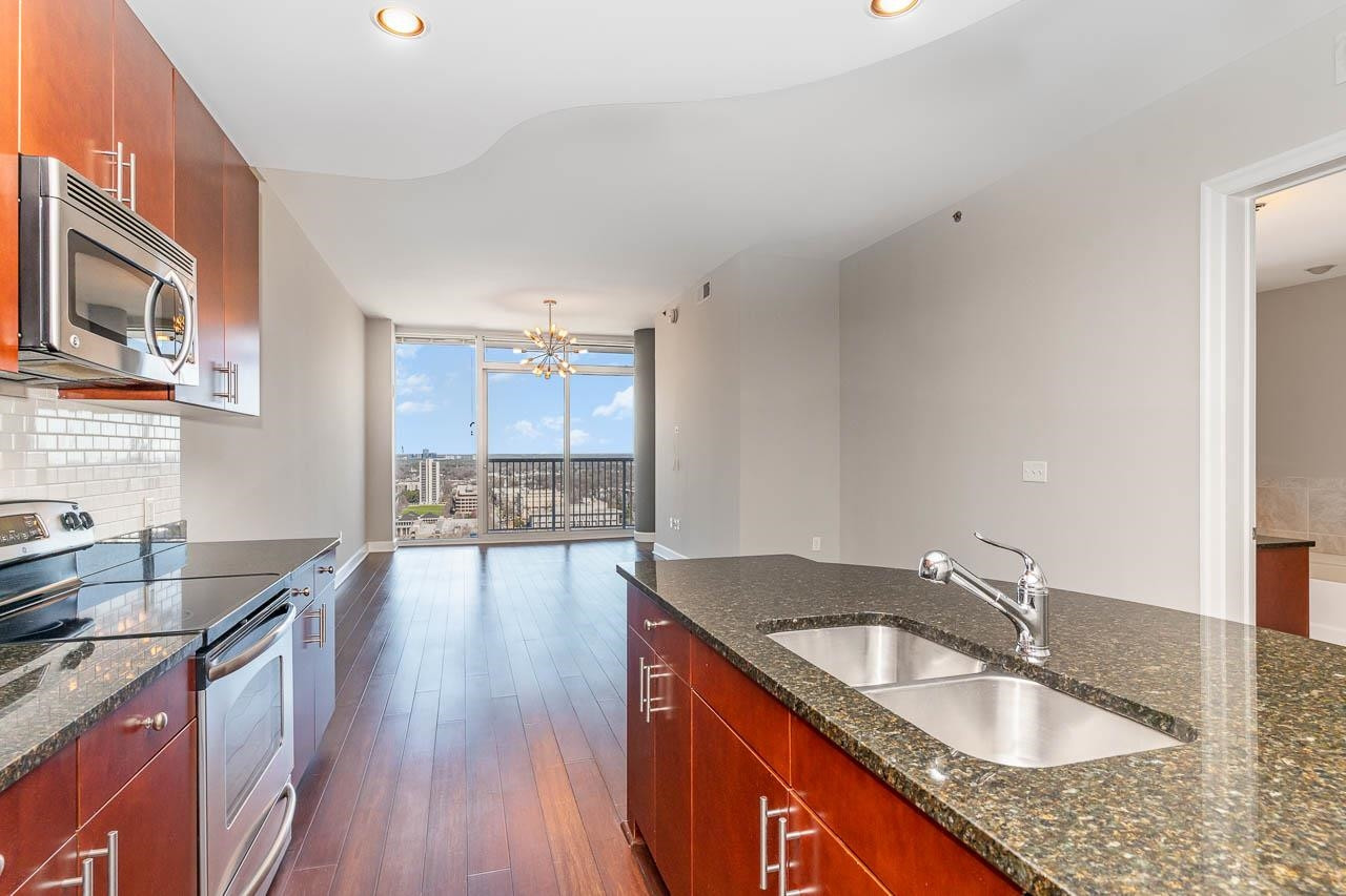 a kitchen with granite countertop a sink stove and cabinets