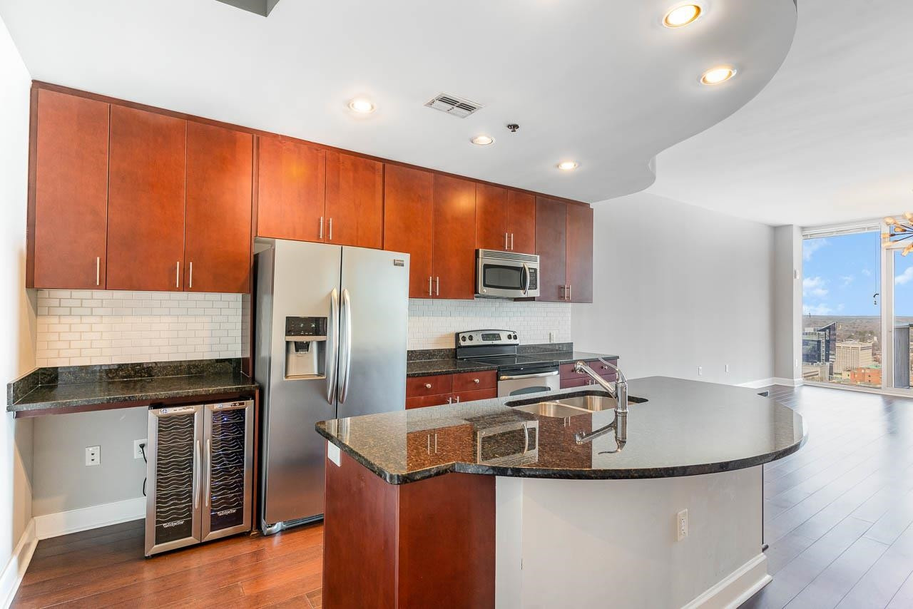 301 Fayetteville Street, Unit 2305 Raleigh, NC 27601 - Photo 2 of 23 a kitchen with stainless steel appliances granite countertop a sink a stove and a refrigerator