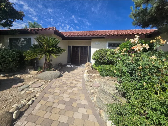 a view of a house with a small yard and potted plants