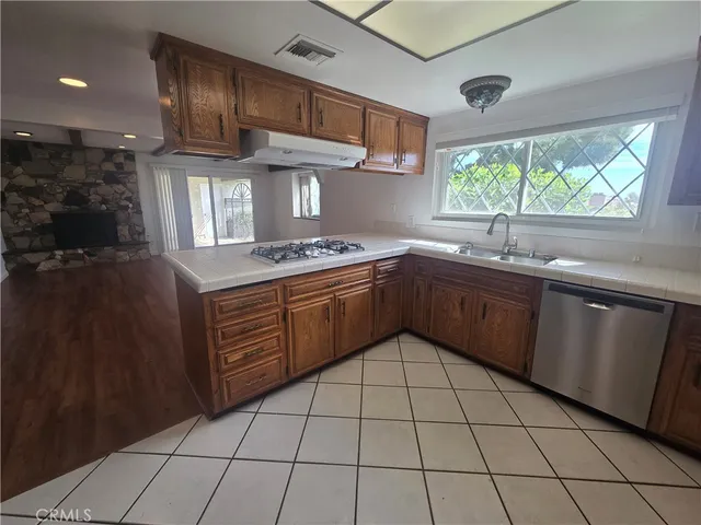 a kitchen with a sink a stove cabinets and window