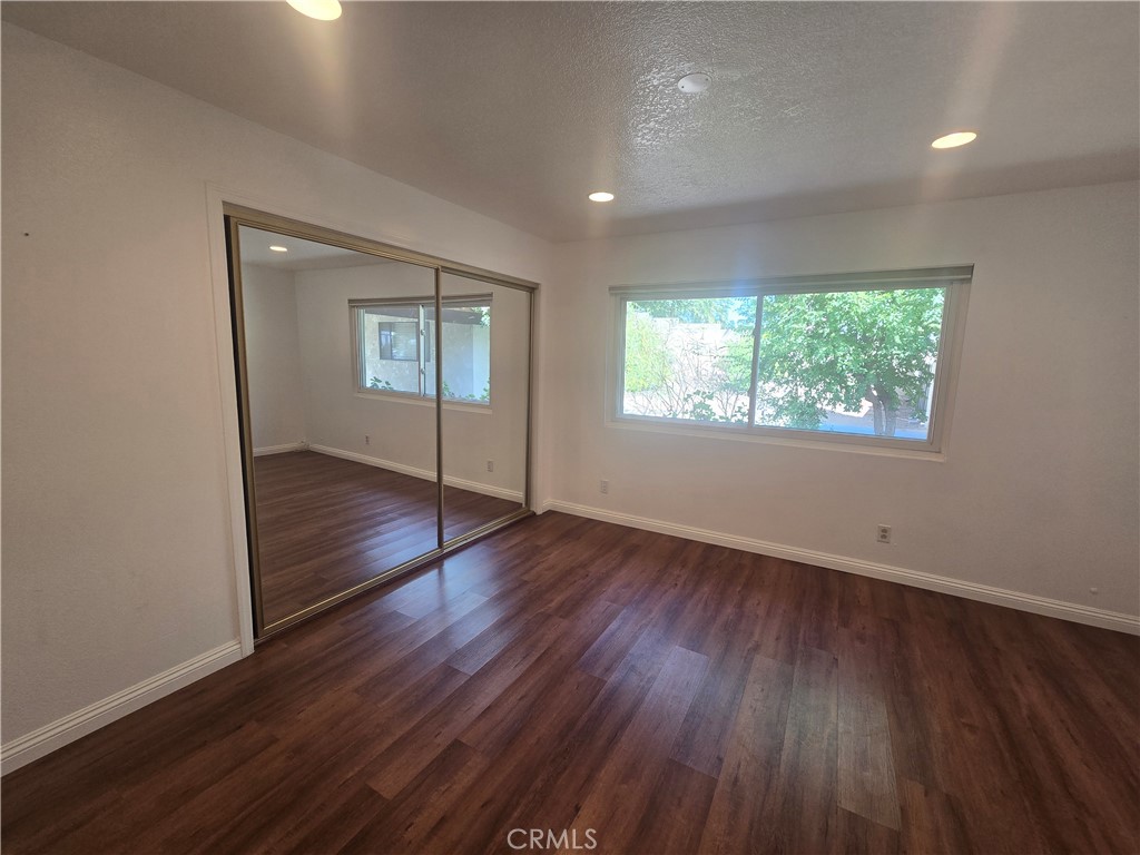 9388 Valley View Street Rancho Cucamonga, CA 91737 - Photo 15 of 40 an empty room with wooden floor and windows