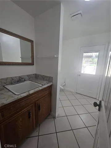 a bathroom with a granite countertop sink and a mirror