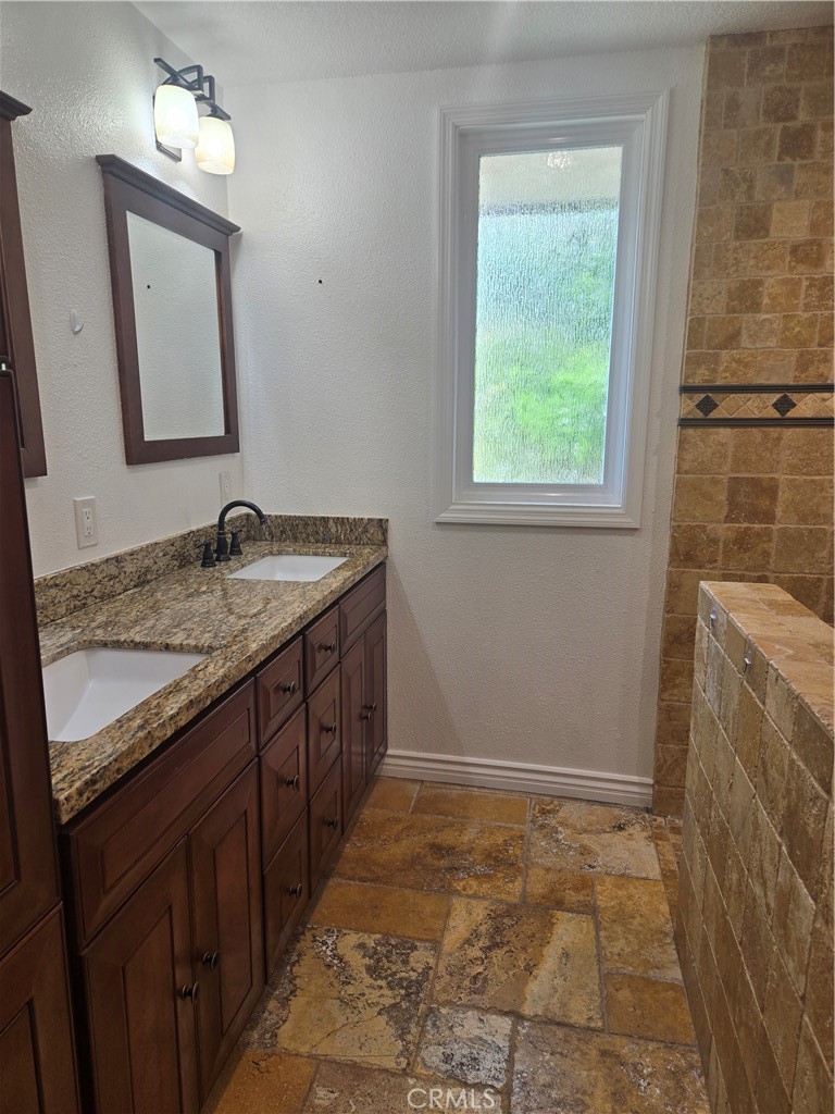 9388 Valley View Street Rancho Cucamonga, CA 91737 - Photo 24 of 40 a bathroom with a granite countertop sink and a mirror