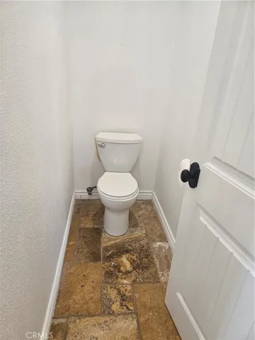 a white toilet sitting next to a shower