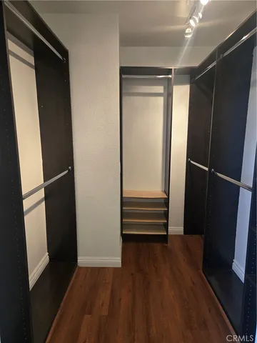 a view of walk in closet with wooden floor and window