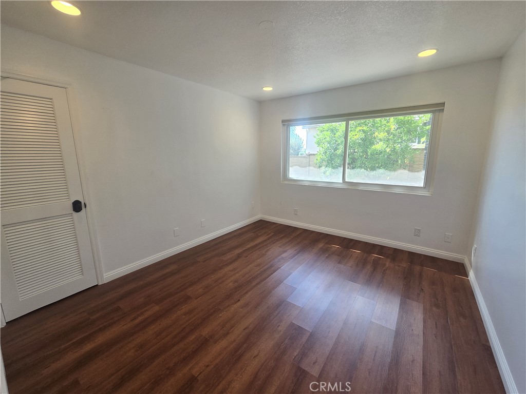 9388 Valley View Street Rancho Cucamonga, CA 91737 - Photo 28 of 40 an empty room with wooden floor and windows