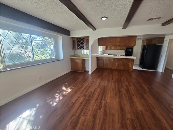 a kitchen with stainless steel appliances a refrigerator a sink dishwasher a stove and white countertops with wooden floor