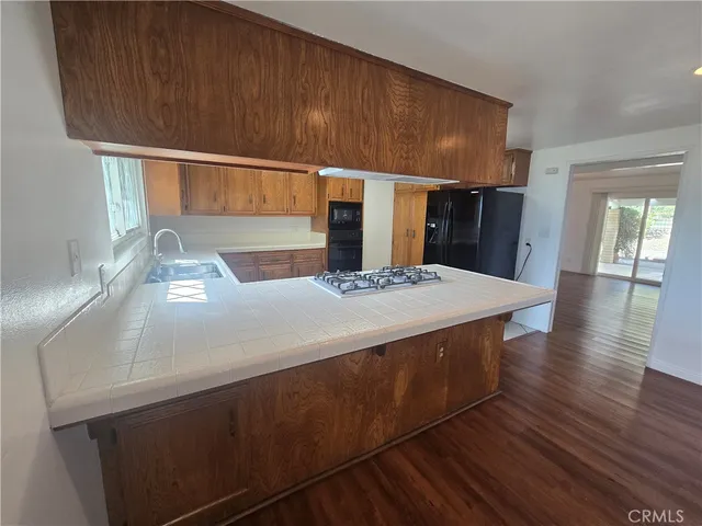 a kitchen with a sink and wooden floor