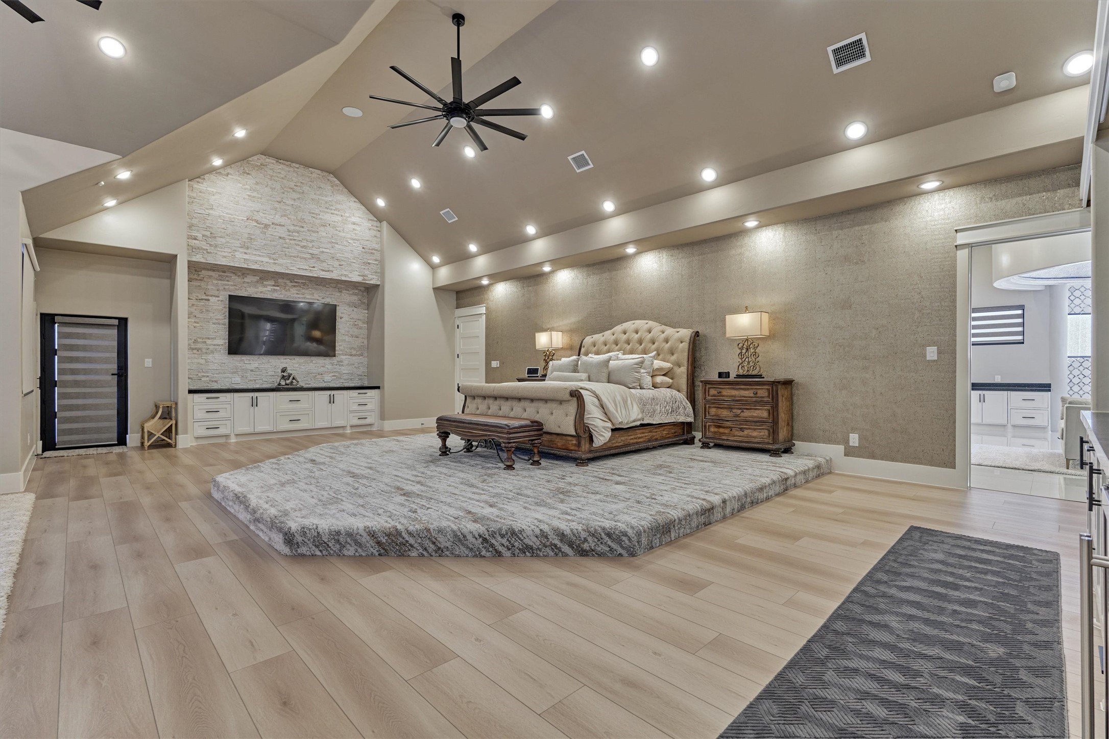 1907 Woerner Road Houston, TX 77090 - Photo 17 of 50 A bedroom fit for royalty with designer carpet, elevated finishes and bed platform, this primary bedroom is a masterpiece. Notice the alabaster stacked stone accent wall, plus sitting area and built-in coffee bar.