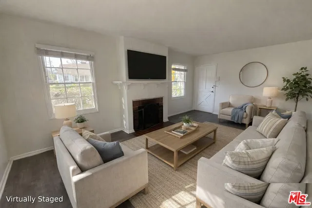 a living room with furniture a flat screen tv and a fireplace