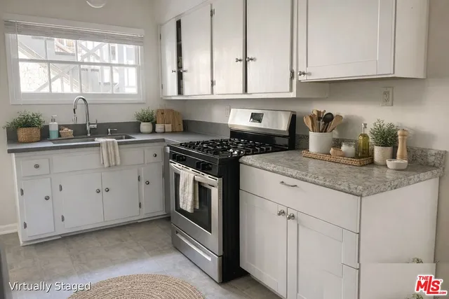 a kitchen with granite countertop white cabinets sink and window