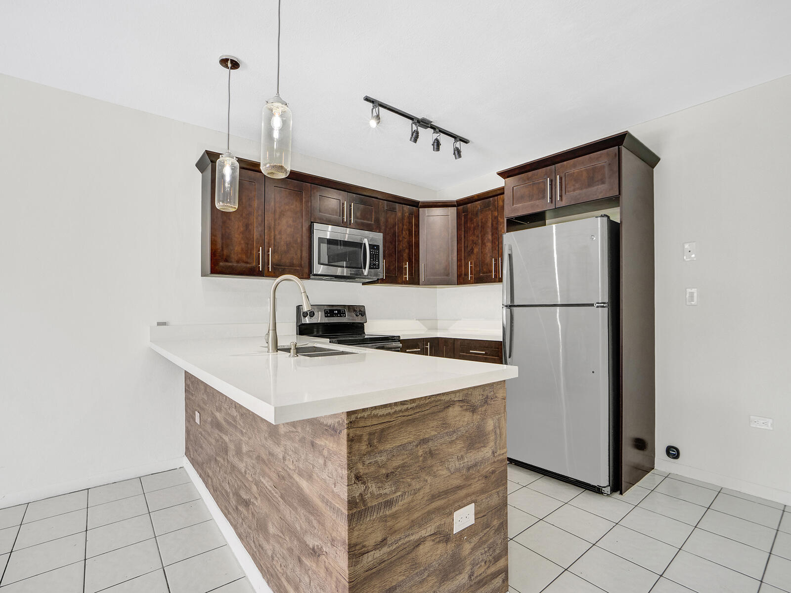 1129 Pebble Beach Lane, Unit 11 Marathon, FL 33050 - Photo 4 of 36 a kitchen with kitchen island a refrigerator a stove a microwave a sink and a refrigerator
