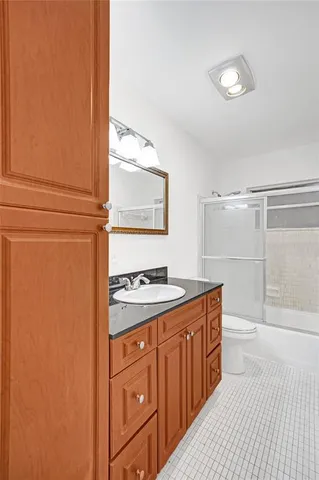 a bathroom with a granite countertop sink toilet and shower