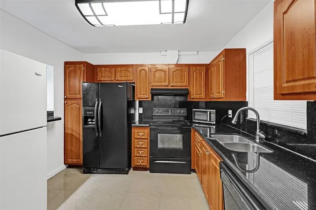 a kitchen with stainless steel appliances granite countertop a refrigerator and a sink