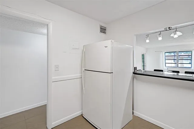 a white refrigerator freezer sitting inside of a kitchen
