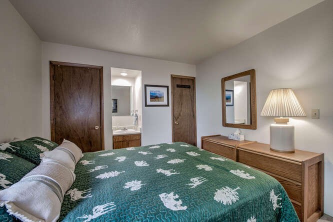 98000 Ryan Gulch Road, Unit E104 Silverthorne, CO 80498 - Photo 12 of 34 a bedroom with a bed and a lamp