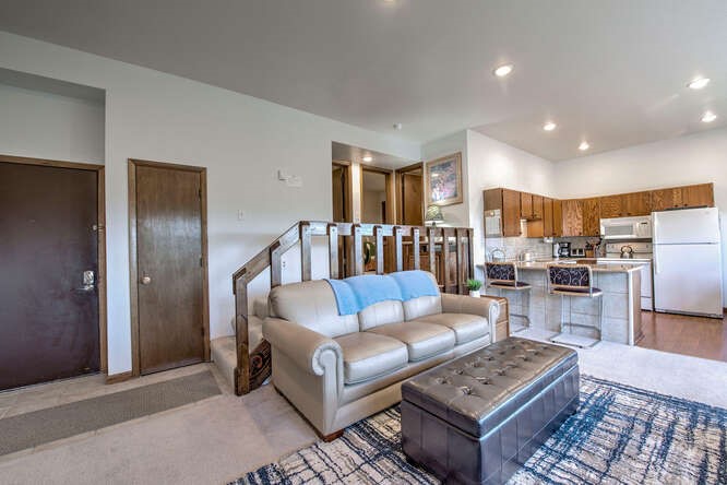 98000 Ryan Gulch Road, Unit E104 Silverthorne, CO 80498 - Photo 5 of 34 a living room with furniture and a view of kitchen