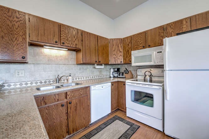 98000 Ryan Gulch Road, Unit E104 Silverthorne, CO 80498 - Photo 8 of 34 a kitchen with a sink a stove and cabinets