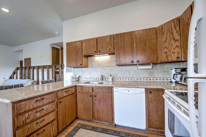 98000 Ryan Gulch Road, Unit E104 Silverthorne, CO 80498 - Photo 9 of 34 a kitchen with stainless steel appliances granite countertop a sink stove and cabinets
