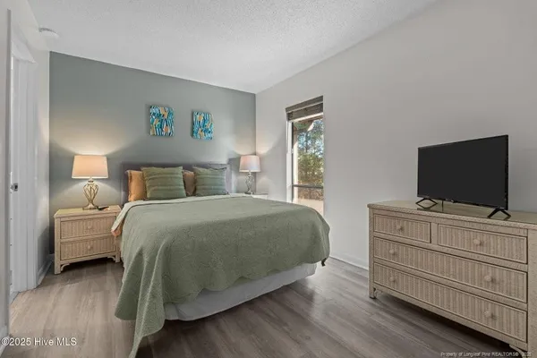 a bedroom with a bed and a flat screen tv