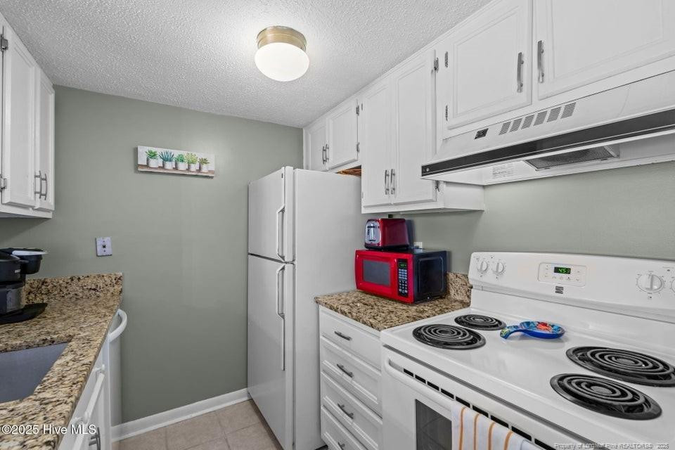 10 Pine Tree Road, Unit 211 Lakeview, NC 28350 - Photo 20 of 36 a kitchen with a stove and a refrigerator