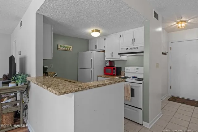 a kitchen with refrigerator and cabinets