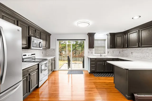 a large kitchen with stainless steel appliances granite countertop a stove a sink dishwasher and a refrigerator