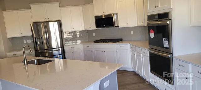 a kitchen with stainless steel appliances a microwave a sink and a refrigerator