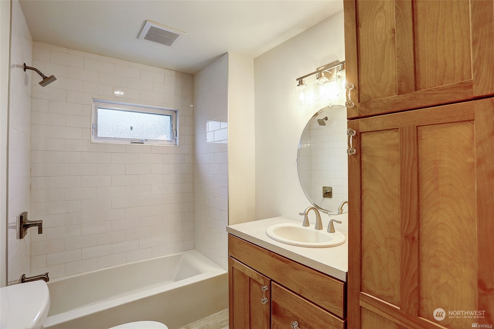 8421 16th Avenue Southwest Seattle, WA 98106 - Photo 11 of 16 a bathroom with a granite countertop sink a mirror and a bathtub