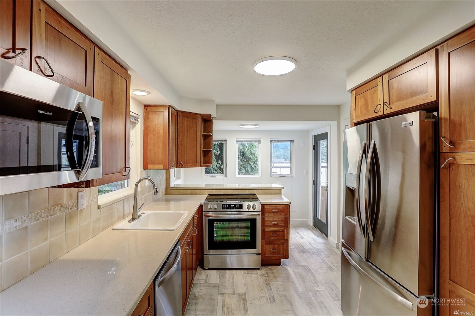 8421 16th Avenue Southwest Seattle, WA 98106 - Photo 7 of 16 a kitchen with stainless steel appliances granite countertop a refrigerator a sink and a stove