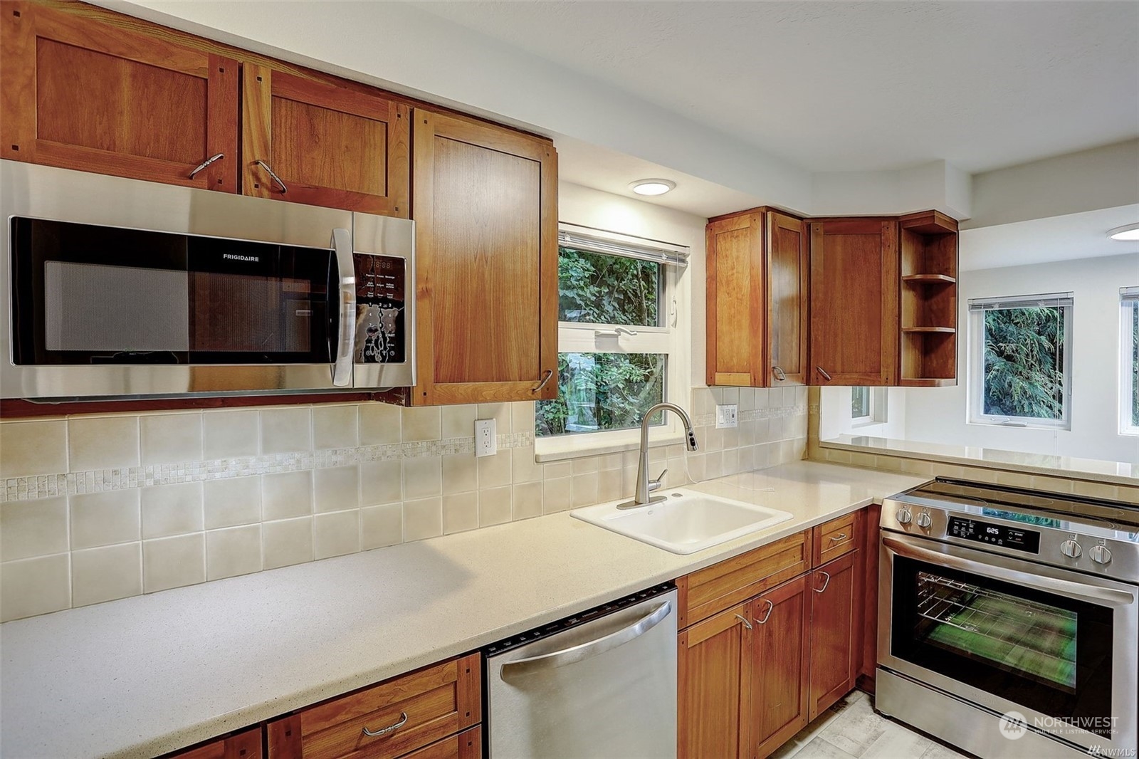 8421 16th Avenue Southwest Seattle, WA 98106 - Photo 8 of 16 a kitchen with stainless steel appliances a sink stove and microwave