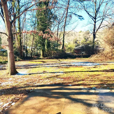 a backyard of a house with large trees and a small yard