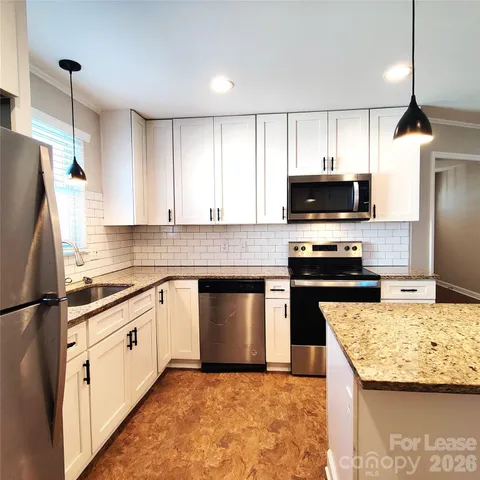 a kitchen with kitchen island granite countertop stainless steel appliances and a sink