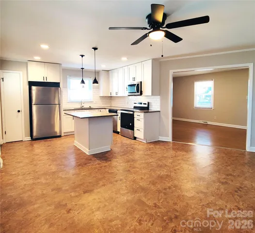 a large kitchen with kitchen island a sink stainless steel appliances and cabinets