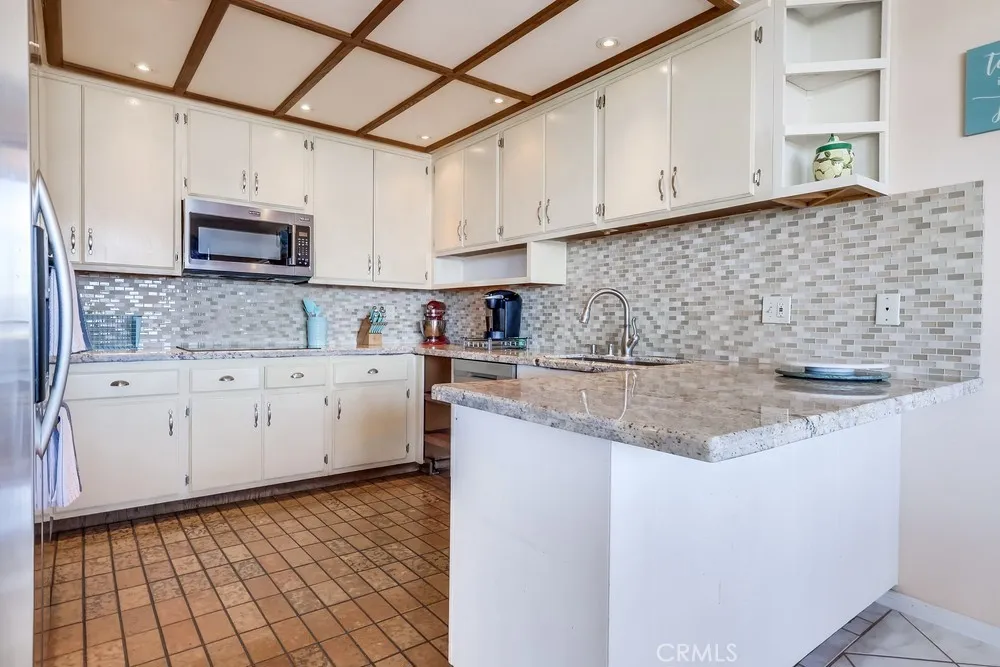 711 West 33rd Street San Pedro, CA 90731 - Photo 32 of 73 a kitchen with stainless steel appliances granite countertop a sink a stove and cabinets
