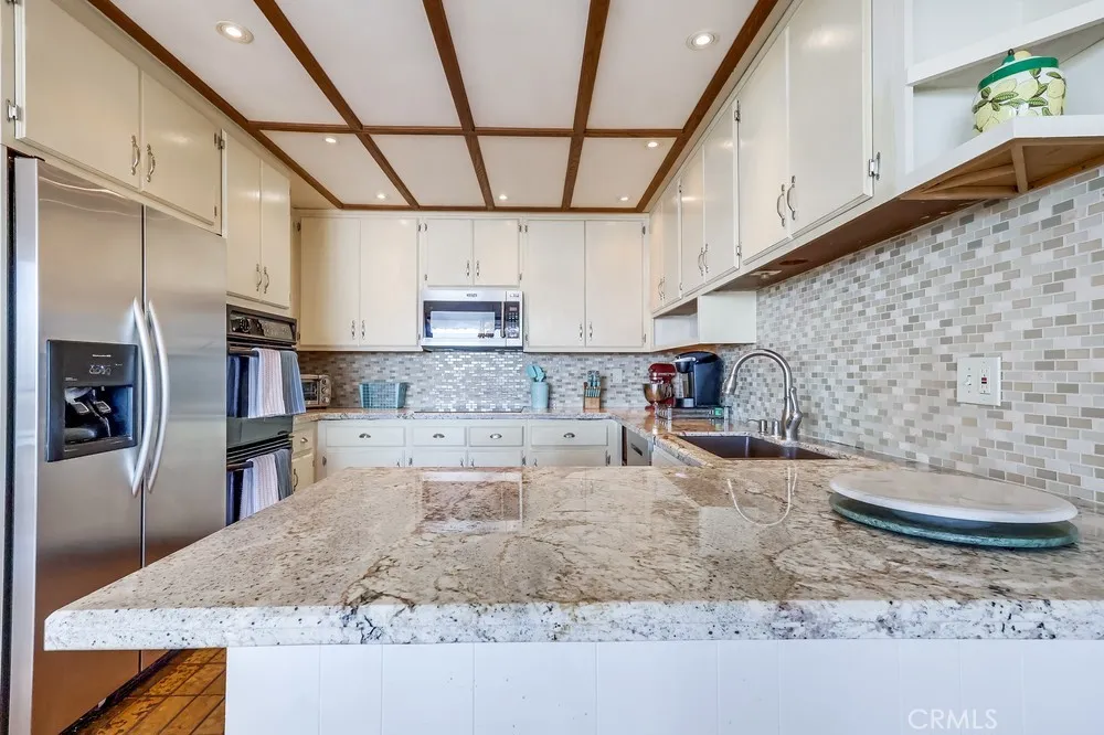 711 West 33rd Street San Pedro, CA 90731 - Photo 33 of 73 a kitchen with stainless steel appliances granite countertop a sink a stove and cabinets